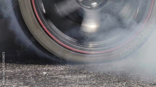 Drag racing car burns rubber off its tires in preparation for the race photo