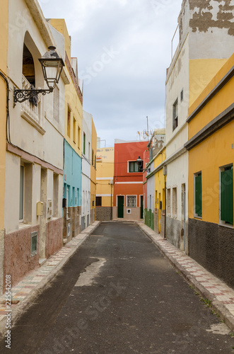 a narrow alley without people with coloured facades © Alexander Baumann