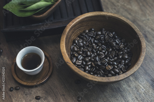 Coffee cups and coffee beans in a bag on a wooden background.