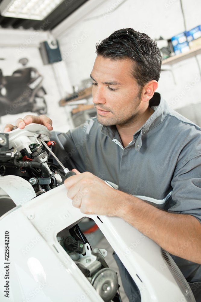 Mechanic working on scooter Mechanic working on scooter