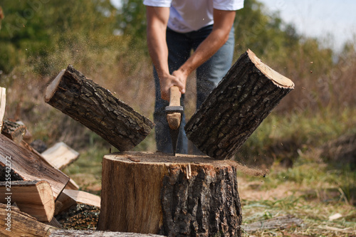 Tableau sur toile Lumberjack chopping wood for winter, Young man chopping woods with an axe