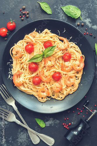 Spaghetti pasta with shrimps and cheese on a dark stone rustic background. Top view,flat lay. Toned photo