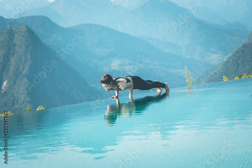 Beautiful Attractive Asian woman practice yoga Plank or Phalakasana Pose on the pool above the Mountain peak in the morning in front of beautiful nature views in SAPA vietnam,Feel so comfortable photo