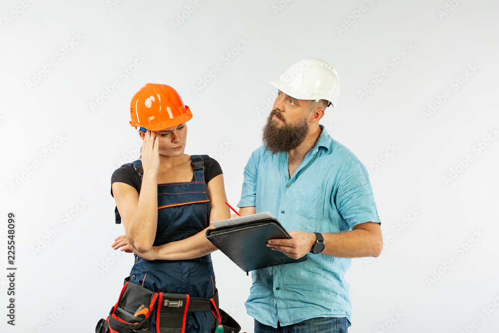 A male architect or engineer meeting with a building woman contractor on white background A male architect or engineer meeting with a building woman contractor on white background