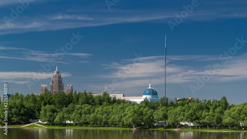 river Ishim timelapse, buildings, premises, tratuar and trees in park. Sunny day. Astana, Kazakhstan photo