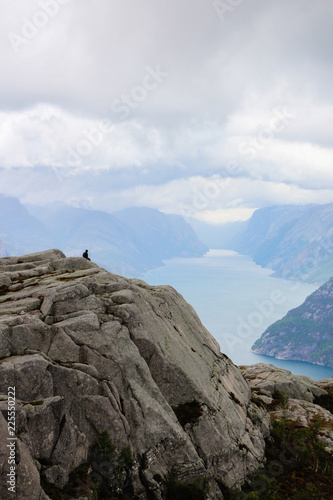 Silhouette alone tourist sitting on the mountain. Norway Preikestolen or Prekestolen.
