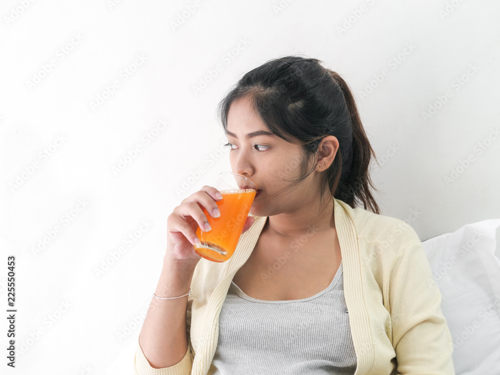 Asian pregnant woman drinking a glass of orange juice, lifestyle concept. Asian pregnant woman drinking a glass of orange juice, lifestyle concept.
