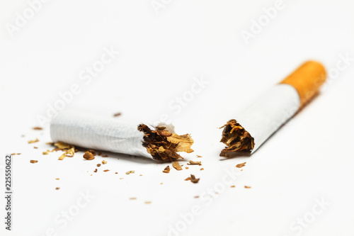 Cigarrillo partido por la mitad sobre fondo blanco aislado. Vista de frente. Copy space photo
