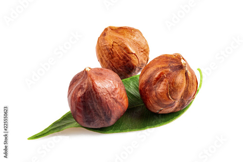 Roasted nuts with green leaf on white background