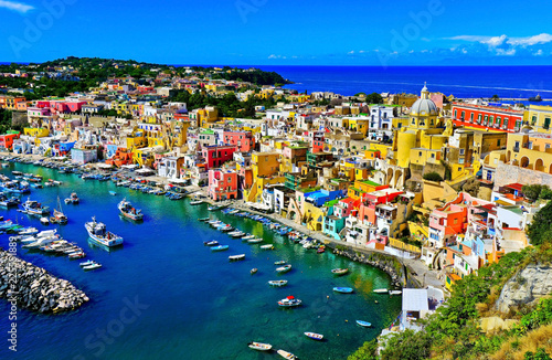 View of the Port of Corricella with lots of colorful houses on a sunny day in Procida Island, Italy. © Javen