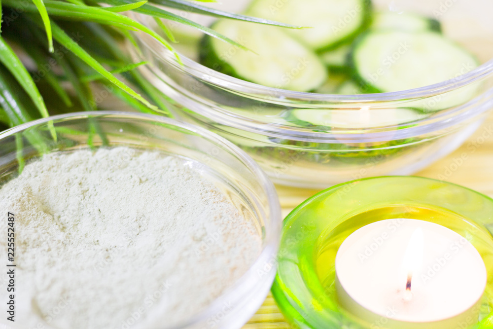 Cucumber home spa and hair care concept. Sliced cucumber, bottles of oil, sea salt, bathroom towel. White board background Cucumber home spa and hair care concept. Sliced cucumber, bottles of oil, sea salt, bathroom towel. White board background