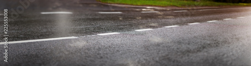 wet black asphalt road and white dividing lines
