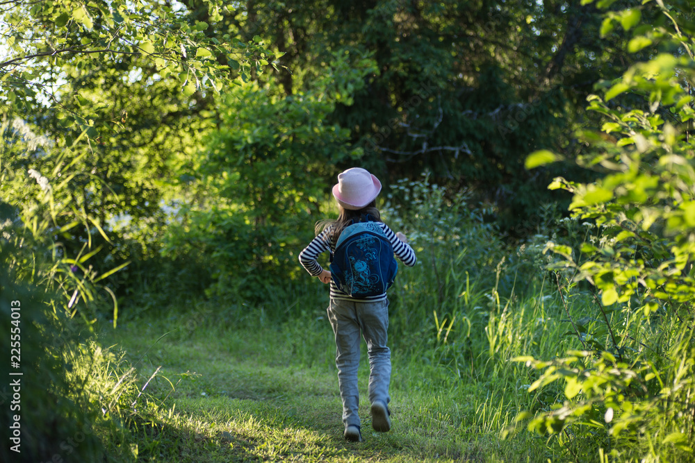 Traveler young girl with backpack walking on path in the tropical forest Traveler young girl with backpack walking on path in the tropical forest
