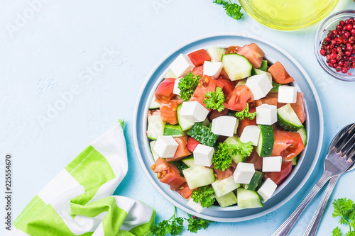 Cucumber feta tomato salad with olive oil dresssing. Top view, space for text.