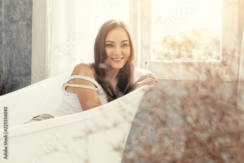 cute teen woman smiling waiting in the bathtub bathroom