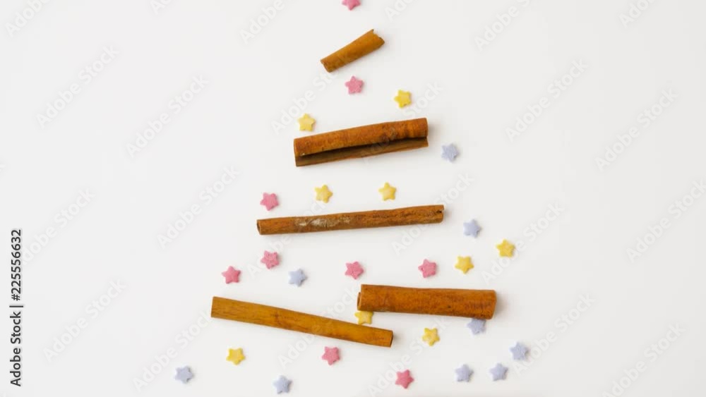 cooking, confectionery and holidays concept - cinnamon sticks and star sprinkles in shape of christmas tree cooking, confectionery and holidays concept - cinnamon sticks and star sprinkles in shape of christmas tree