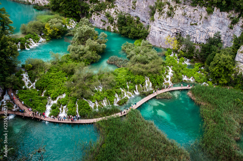 Plitvice National Park  Croatia. Wood plank path through green forest and over the water