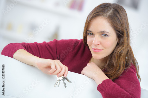 happy woman holding house model and home keys