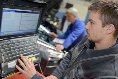 car mechanic analyzing car electronic in auto repair service