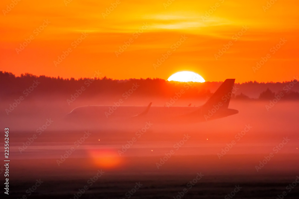 Taxiing a passenger airplane in the fog and sunrise
