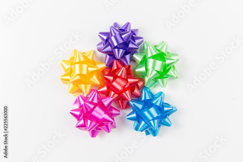 Pink, yellow, red, green, blue and purple gift wrap bows top view on white background