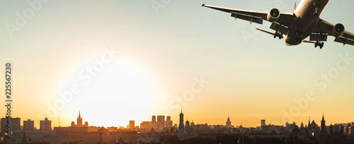 Photography plane flies over the city at sunset, flies away