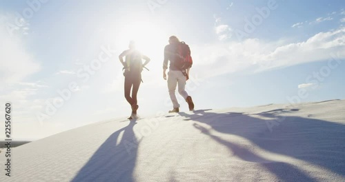 Couple with back pack walking in the desert 4k photo