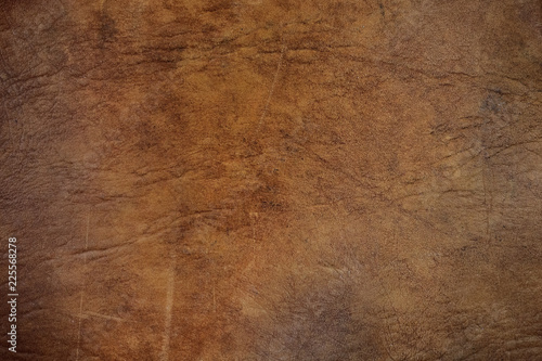 Textured background of worn brown leather upholstery
