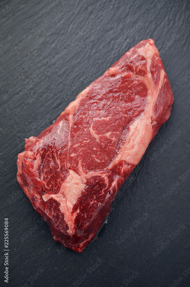 Raw beef steak on a dark table. Raw beef steak on a dark table.