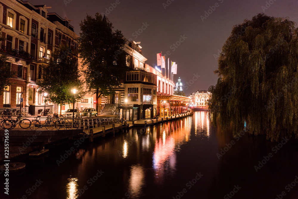 Night city view of Amsterdam bridge and typical dutch houses, Holland, Netherlands.