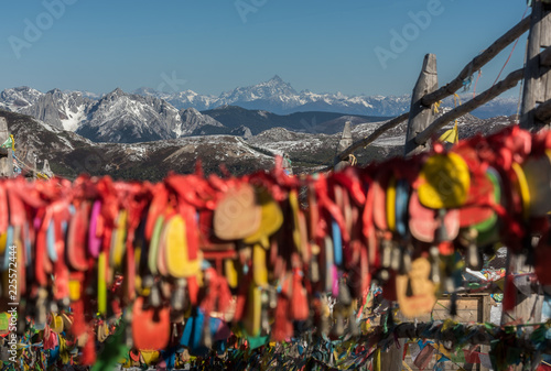 Layer of snow mountain range and snow peak with blur hanging amulet foreground in sunny day in clear blue sky at the top of Shika Snow Mountains, Shangri La, China