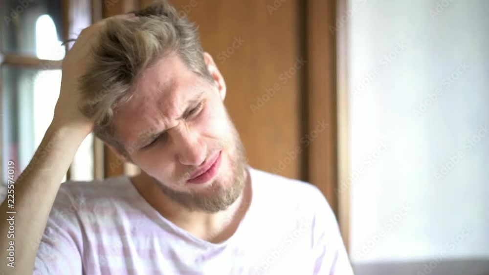 close up portrait of young bearded person suffering from strong headache close up portrait of young bearded person suffering from strong headache