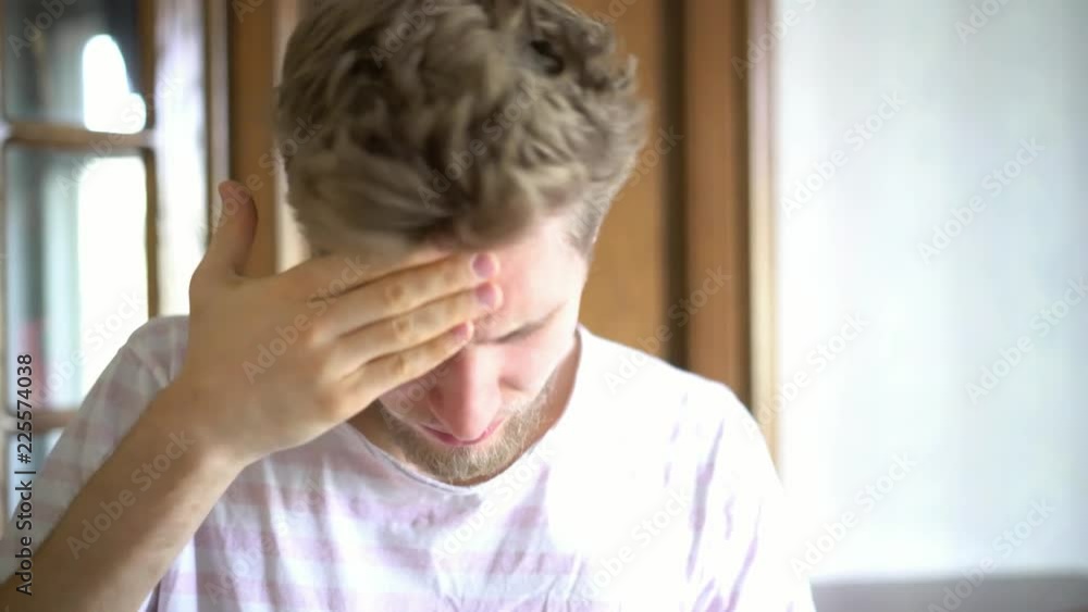 close up portrait of young bearded person suffering from strong headache close up portrait of young bearded person suffering from strong headache