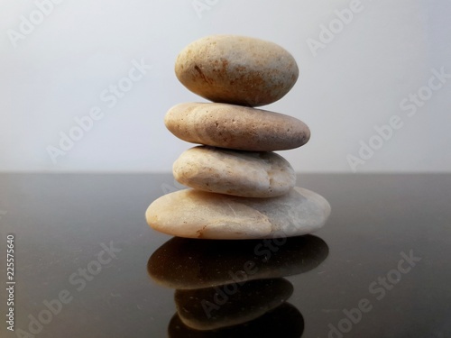 A stack of zen stones on a black table against grey background. Concept of Harmony  Balance and Meditation  Spa  relax