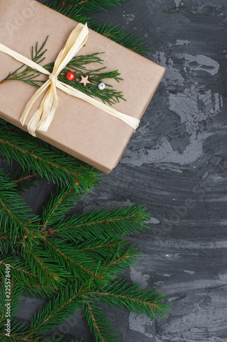 Christmas gift wrapped in craft paper on dark concrete background. Flat lay, top view, copy space