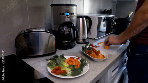 Man chopping vegetables for salad, vegetarian preparing healthy dinner, diet