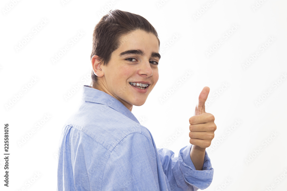 portrait of young teenager with braces and sign of approval portrait of young teenager with braces and sign of approval