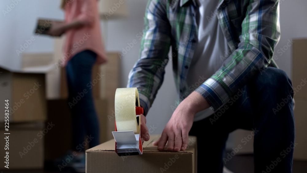 Young couple packing their things in boxes, moving from dormitory to own house
