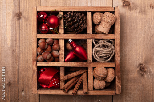 Wooden box with Christmas decorations on wooden table.