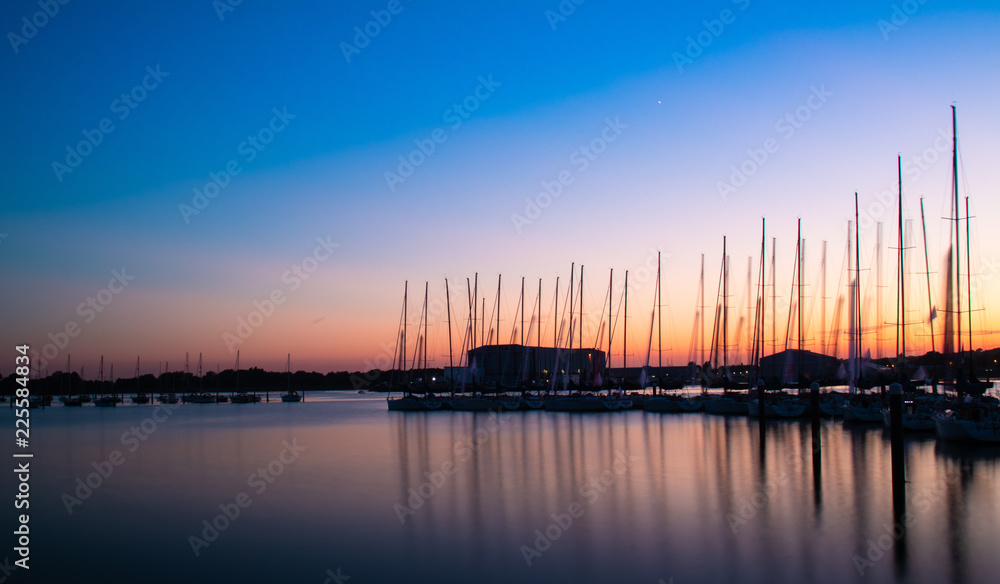 masts on boats at sunset