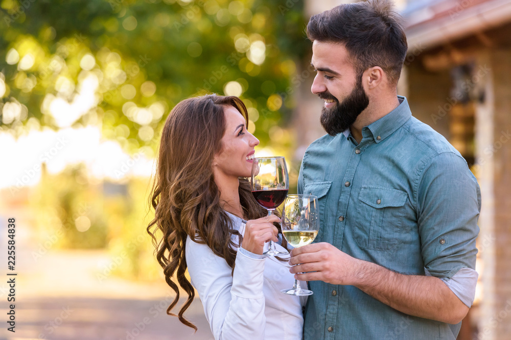 Portrait of young smiling man and woman tasting wine at winery vineyard - Young people enjoying harvest time together. Romantic love. Portrait of young smiling man and woman tasting wine at winery vineyard - Young people enjoying harvest time together. Romantic love.