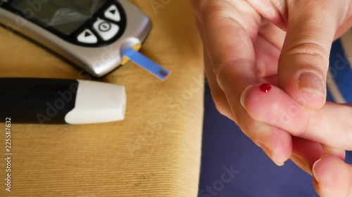 4K Pregnant women pricking her finger to test blood sugar glycaemia photo