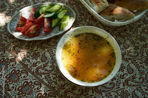 Traditional Azerbaijan dushbere soup with meat dumplings and fresh vegetable sliced tomatoes  cucumbers and pita bread