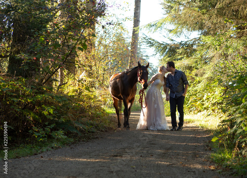 Couple kissing while walking with horse © Sharon