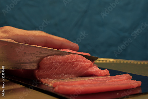 Man slicing piece of red fish