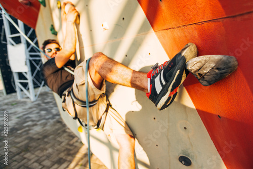 Young man exercising in climbing gym