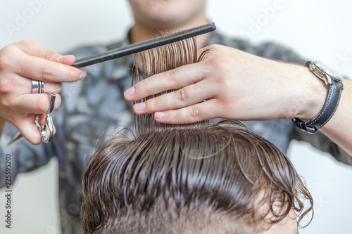 Skillful hairdresser cutting male hair