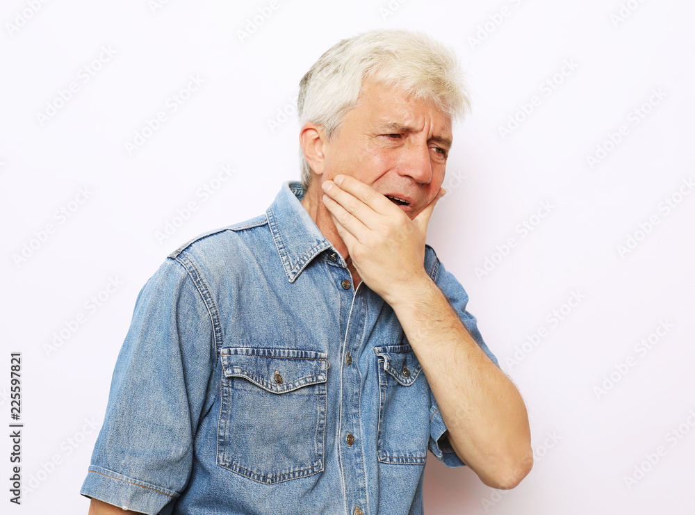 Health issues problems, people and sickness concept - studio shot of unhappy senior man pressing cheek trying to soothe toothache, having mournful painful facial expression. Health issues problems, people and sickness concept - studio shot of unhappy senior man pressing cheek trying to soothe toothache, having mournful painful facial expression.