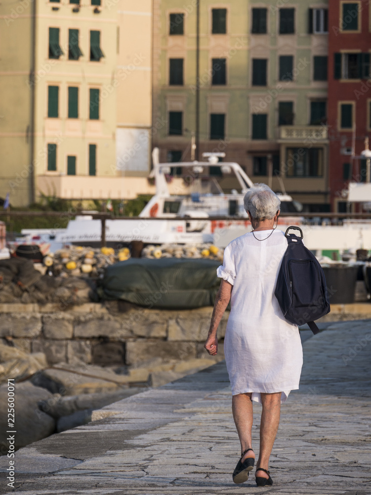 elderly woman walks on the pier