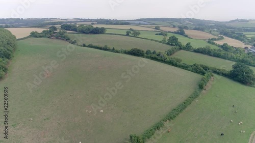 Aerial shot tracking forward over hilly fields in the countryside. West Somerset, Washford. photo